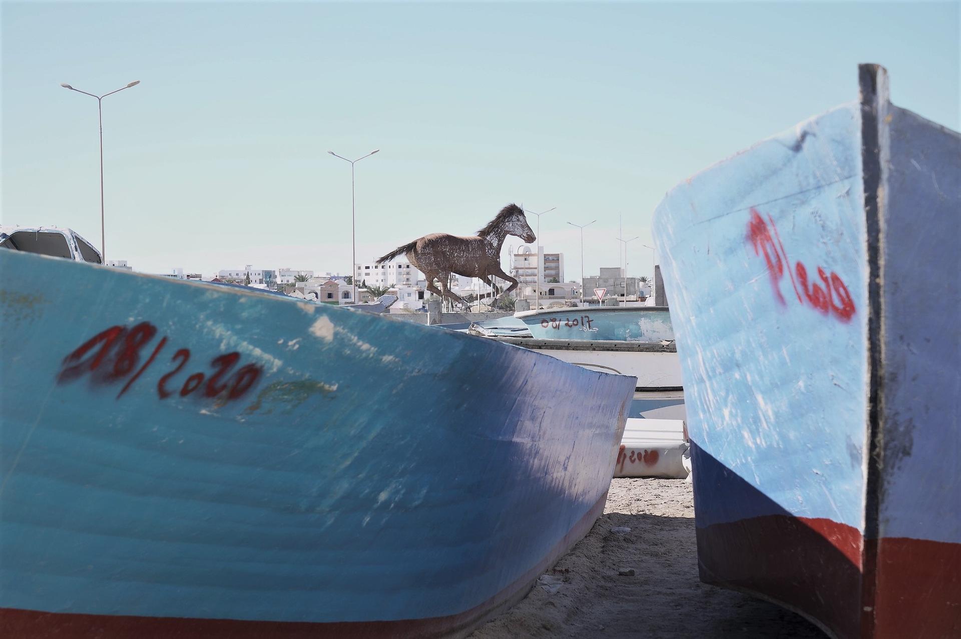 Kæntrede både fra Libyen og Tunesien efterladt i bådkirkegården i Zarzis. En påmindelse om de farlige ruter, migranter tvinges ud på. Foto: Ahlam Chemlali